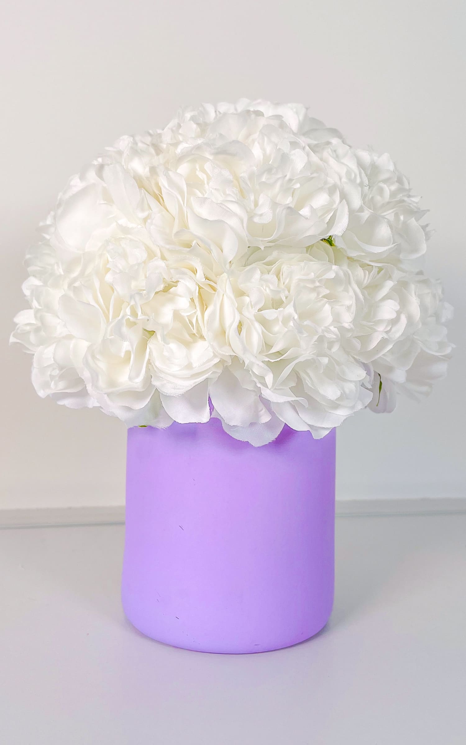 Gardenias Blancas en Florero Morado Mediano